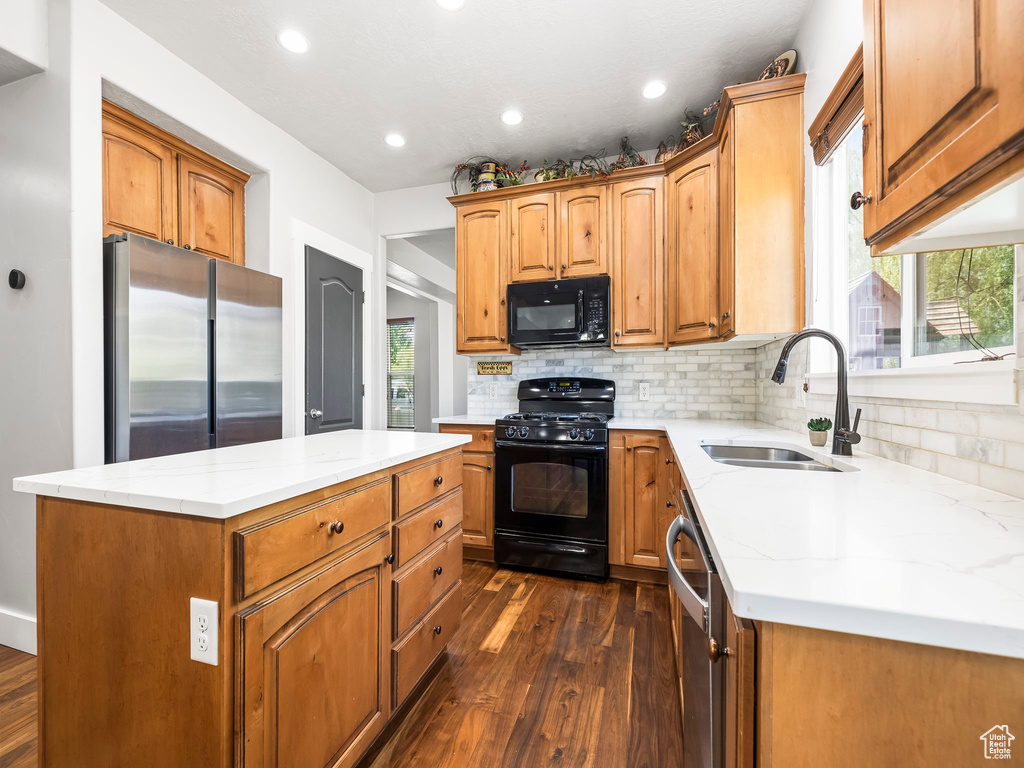 Kitchen featuring black appliances, a sink, dark wood-style floors, tasteful backsplash, and recessed lighting