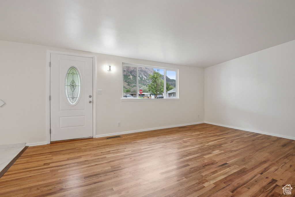 Foyer with light wood-type flooring and baseboards