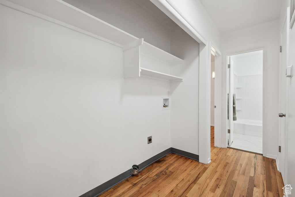 Laundry area with light wood-style flooring, baseboards, hookup for an electric dryer, and washer hookup