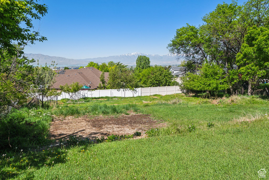 View of yard featuring a mountain view and fence