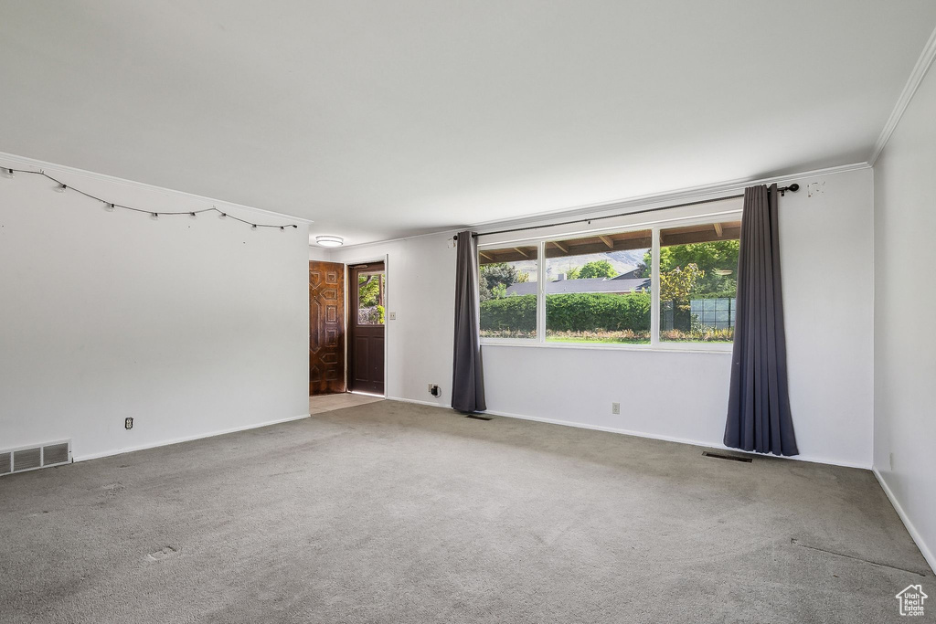 Empty room with carpet flooring, baseboards, and ornamental molding