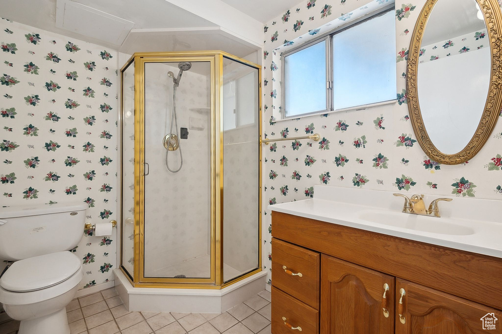 Bathroom with wallpapered walls, tile patterned flooring, toilet, a stall shower, and vanity