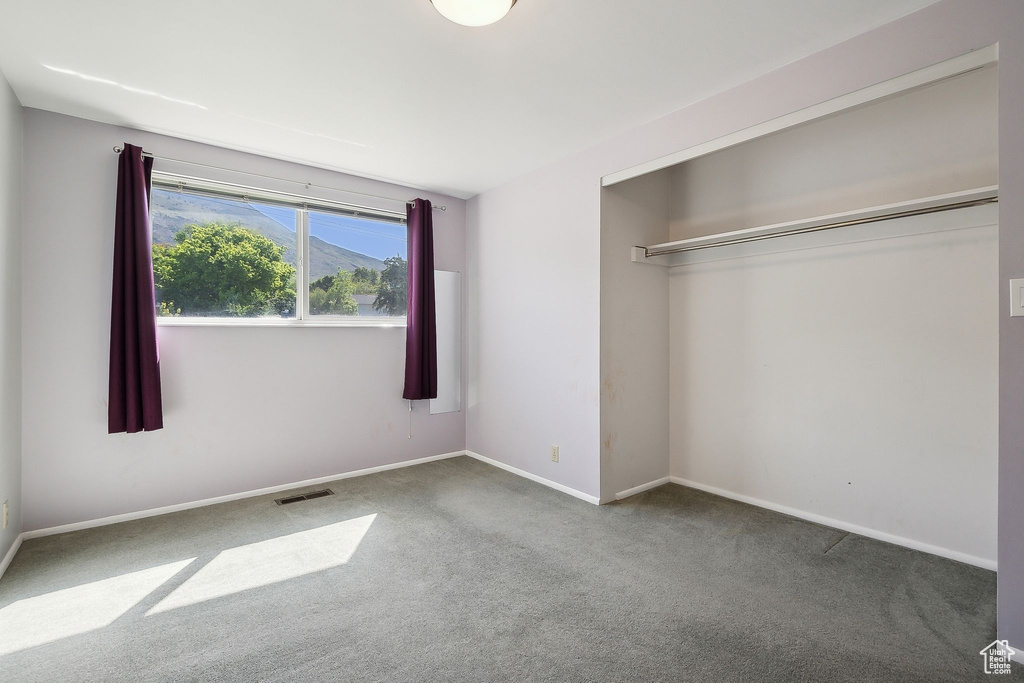 Unfurnished bedroom featuring carpet flooring and baseboards
