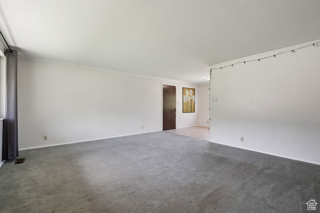 Carpeted spare room featuring baseboards and ornamental molding