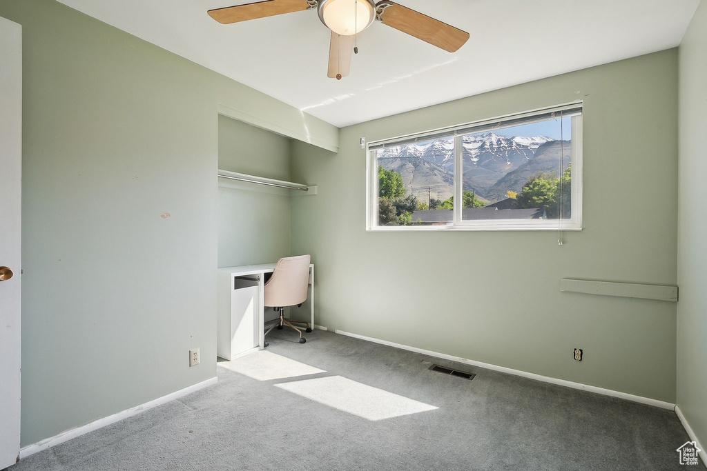 Unfurnished office with ceiling fan, carpet flooring, and baseboards