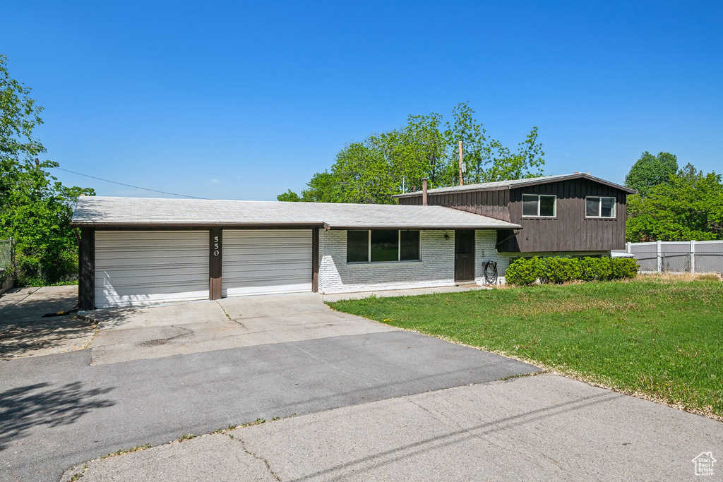 Split level home with brick siding, driveway, and an attached garage