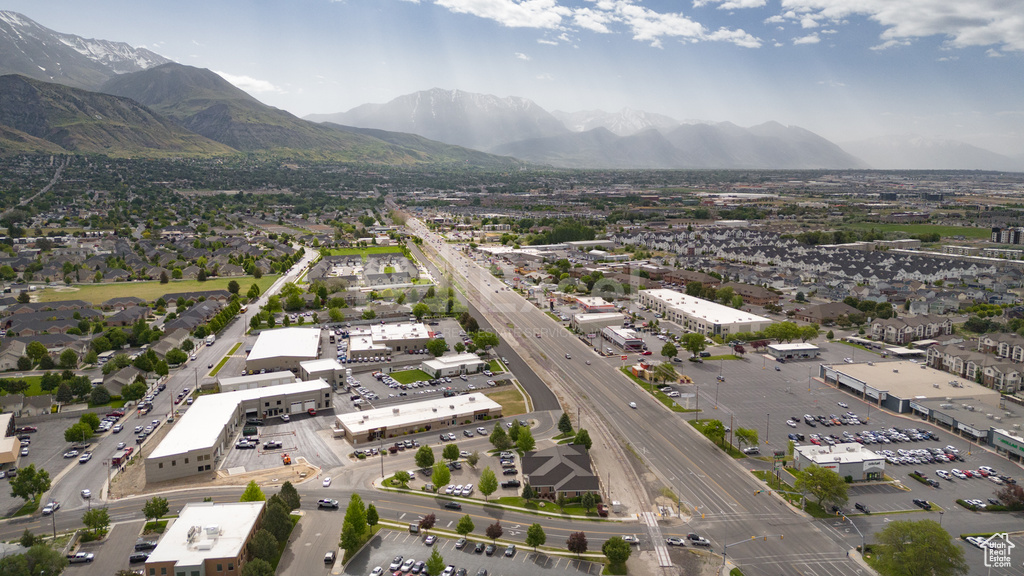 Aerial view of property and surrounding area with a major roadway and a mountain backdrop