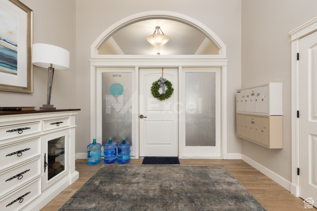 Foyer featuring light wood-style flooring, baseboards, and mail area
