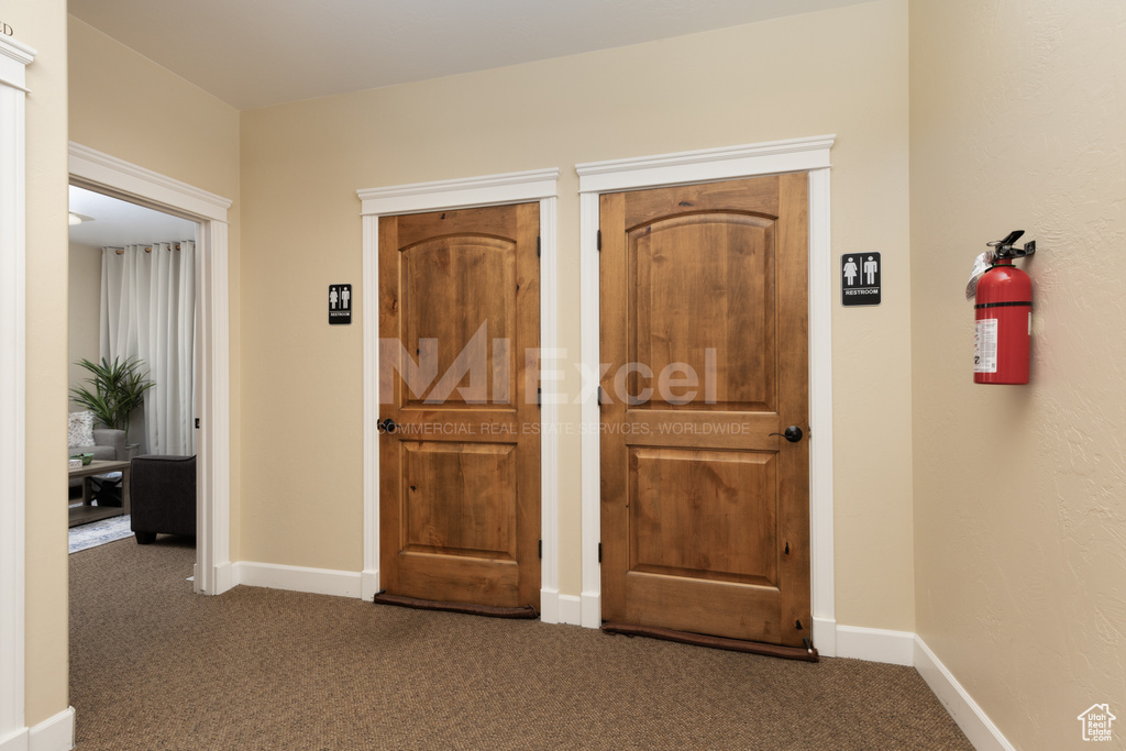 Foyer with carpet floors and baseboards