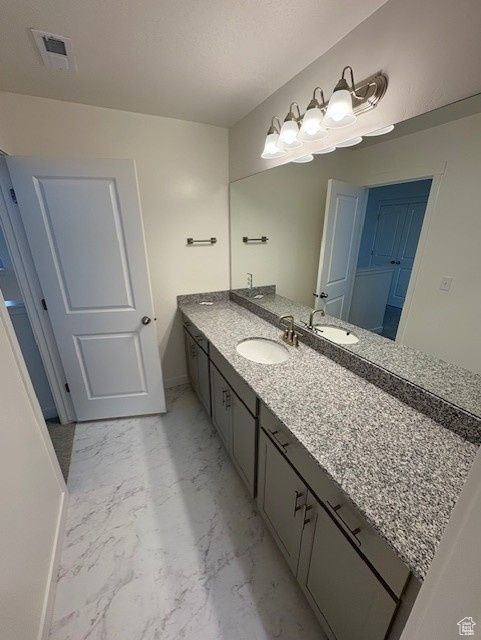 Bathroom featuring marble finish floors, vanity, and baseboards