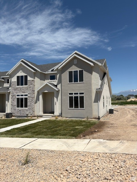 Traditional-style home with stone siding, a mountain view, and a front yard