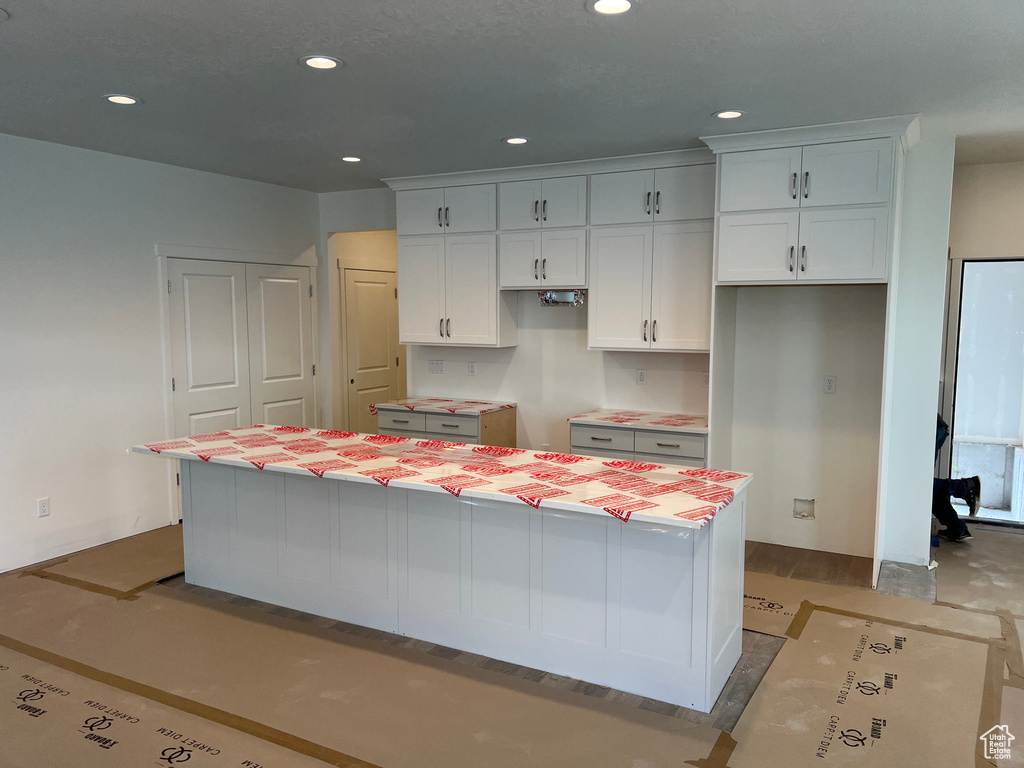 Kitchen with white cabinets, recessed lighting, and a kitchen island