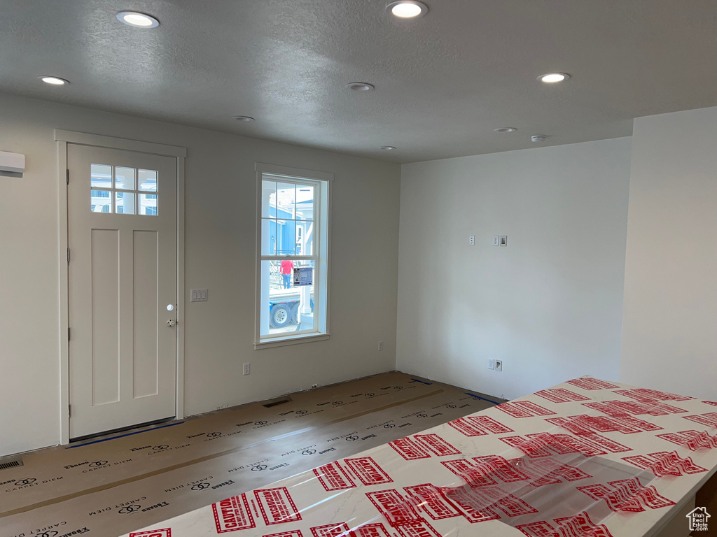 Entrance foyer featuring recessed lighting, a textured ceiling, and a wall mounted air conditioner