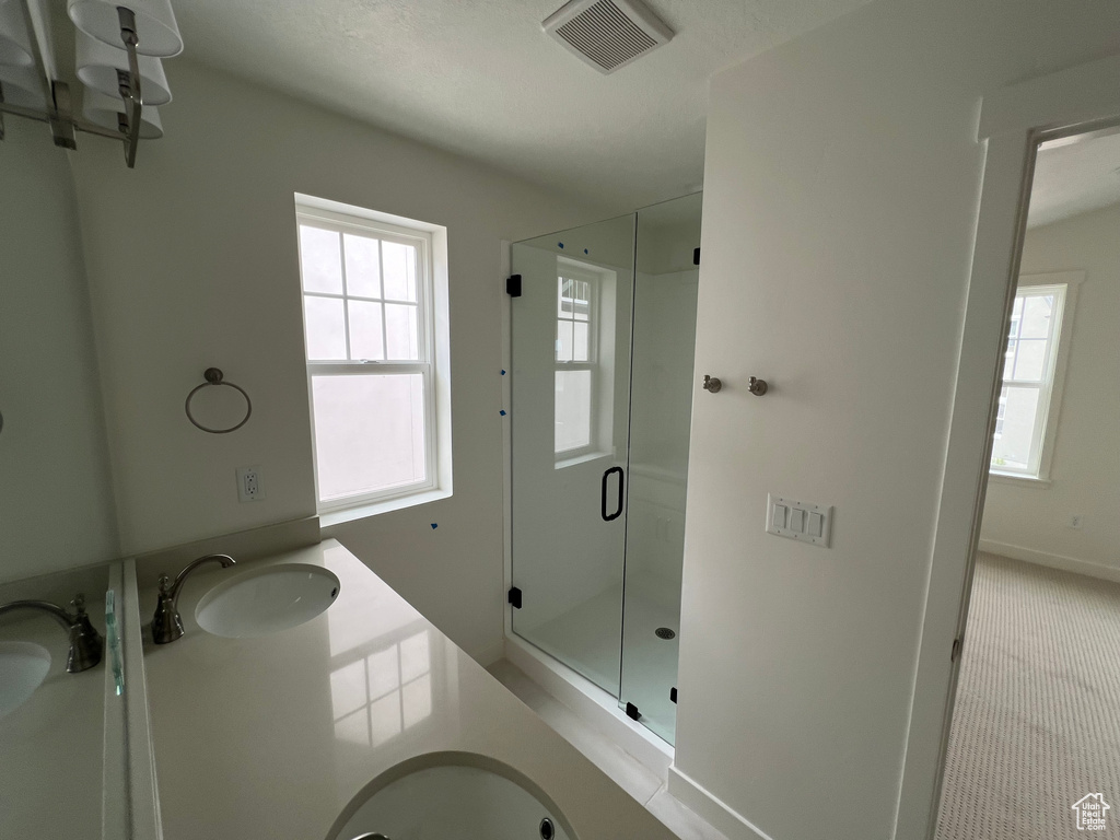 Full bath with a shower stall and double vanity