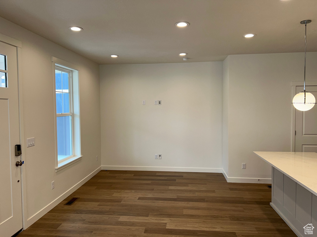 Unfurnished dining area featuring healthy amount of natural light, recessed lighting, and dark wood-style flooring