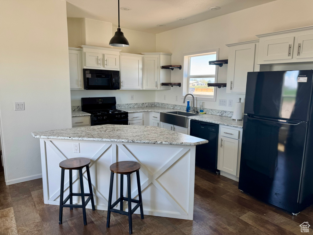 Kitchen featuring black appliances, open shelves, a sink, a center island, and white cabinetry