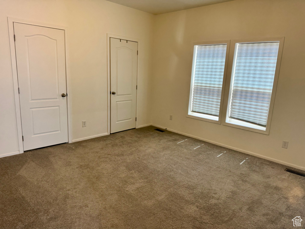 Unfurnished room featuring carpet floors and baseboards