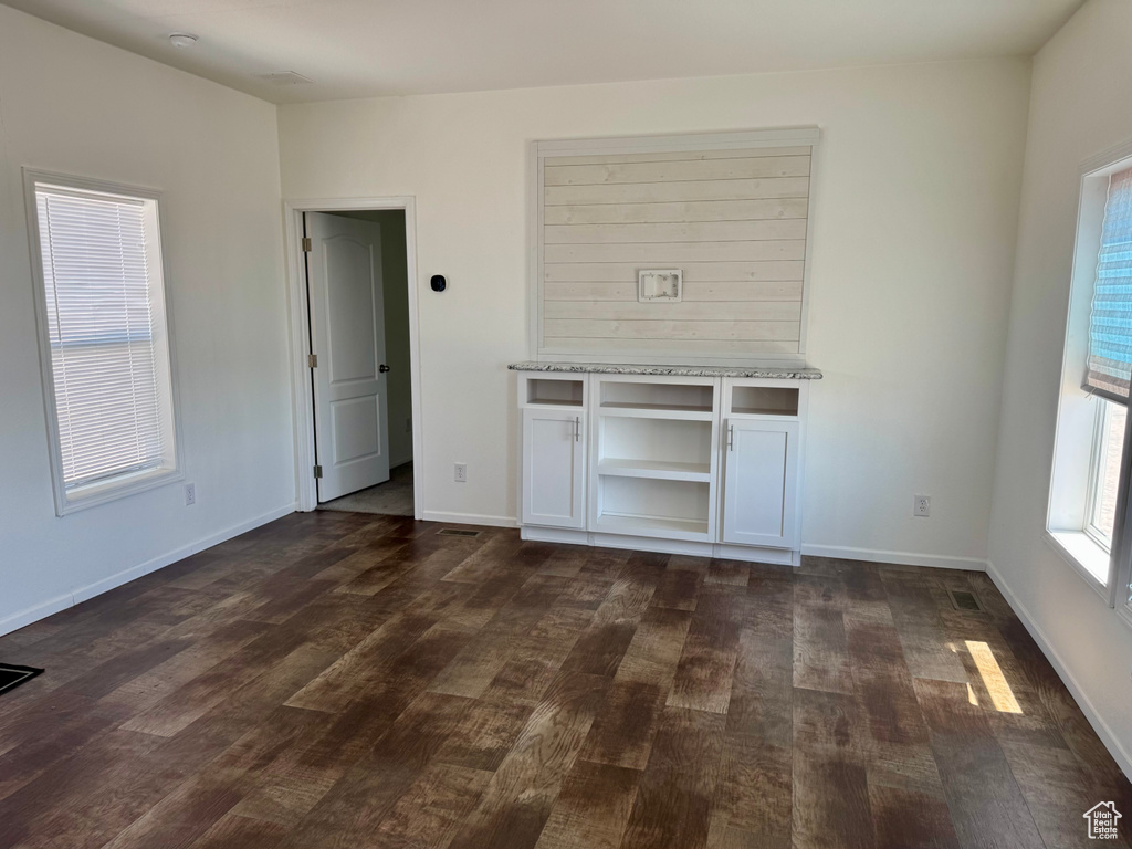 Unfurnished living room with dark wood finished floors and baseboards