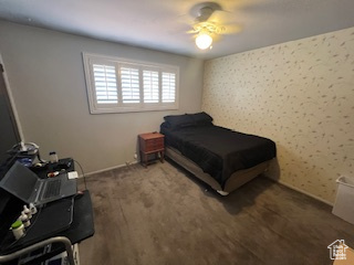 Bedroom featuring ceiling fan, baseboards, and wallpapered walls