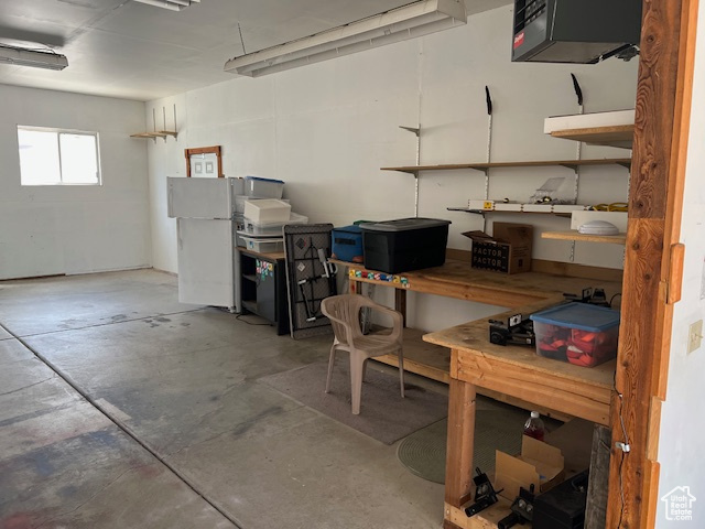 Below grade area with a heating unit and freestanding refrigerator
