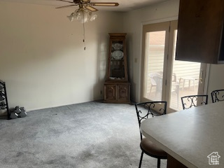 Carpeted dining area with a ceiling fan