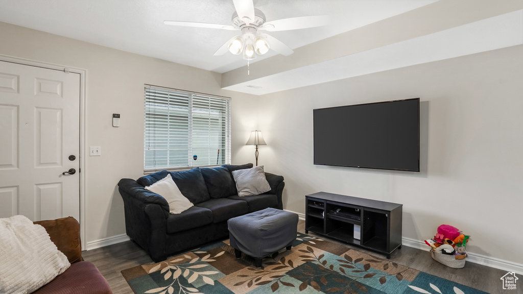 Living room featuring wood finished floors, a ceiling fan, and baseboards
