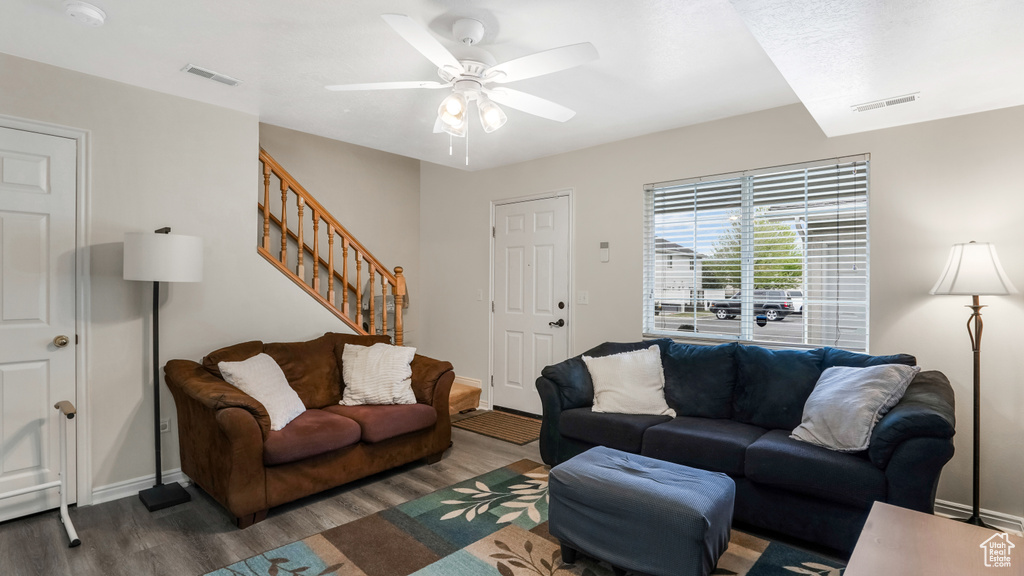 Living area with wood finished floors, stairway, a ceiling fan, and baseboards