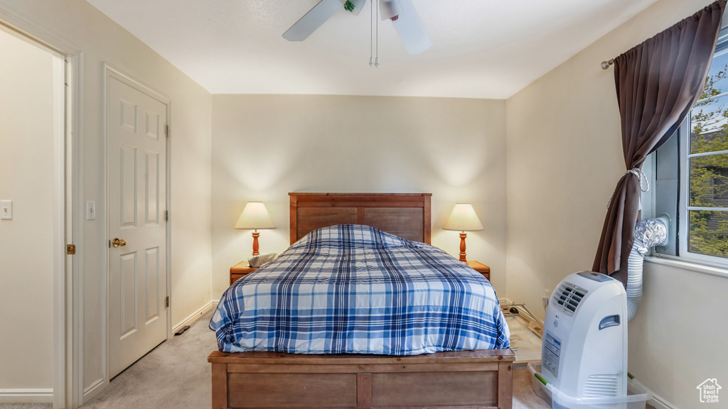 Bedroom with light carpet, a ceiling fan, and baseboards
