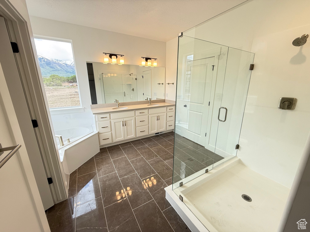 Bathroom with a shower stall, a bath, double vanity, and marble finish flooring
