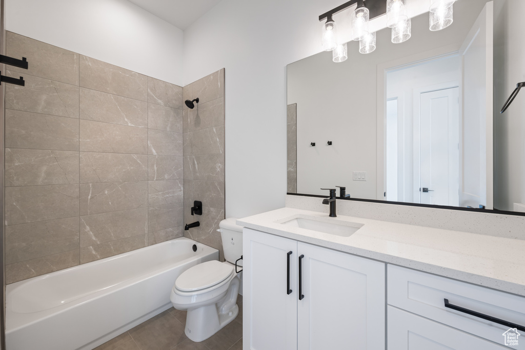 Bathroom featuring toilet, vanity, bathtub / shower combination, and tile patterned floors