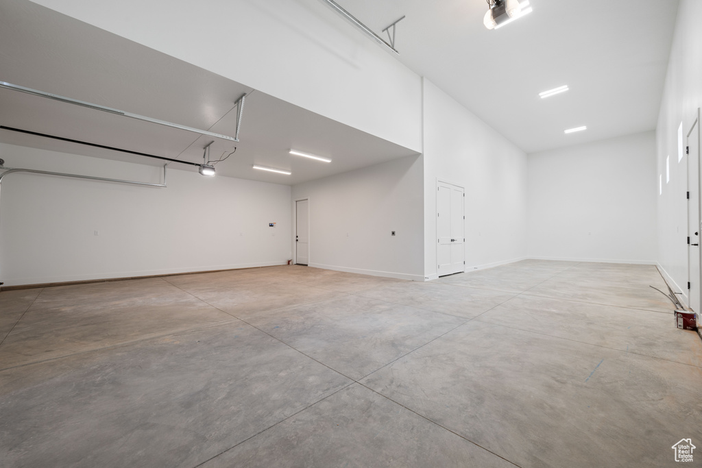 Garage with a garage door opener and baseboards