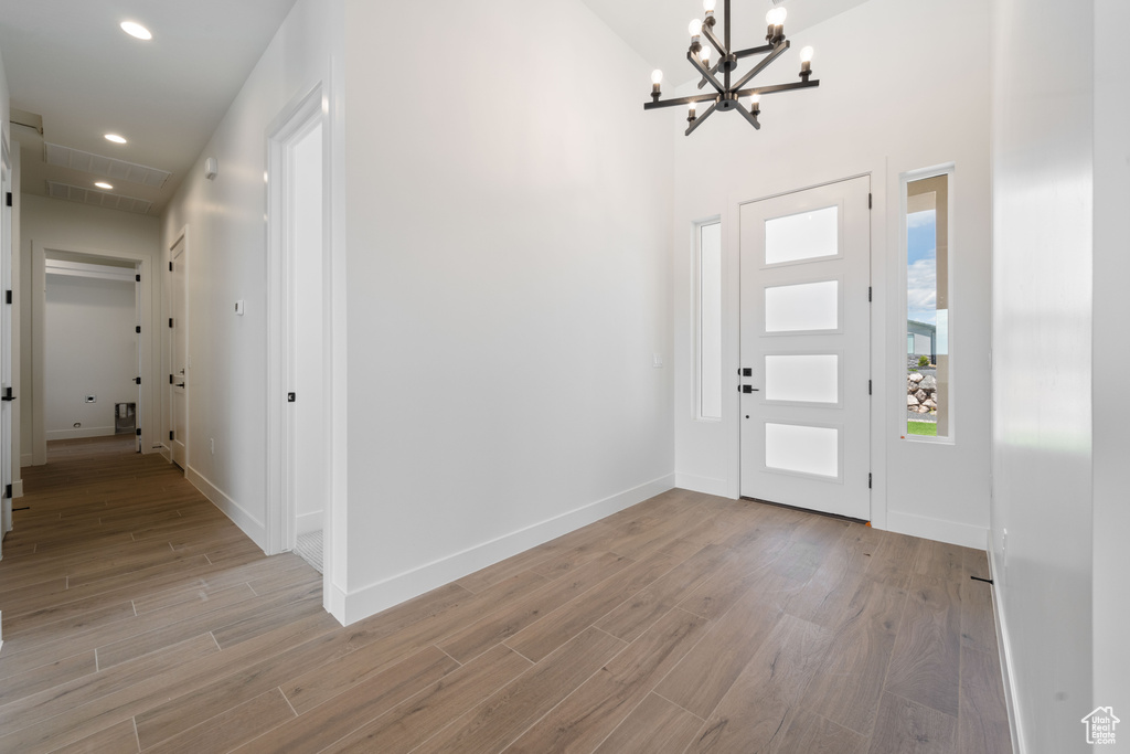Foyer featuring a chandelier, light wood-type flooring, recessed lighting, and baseboards