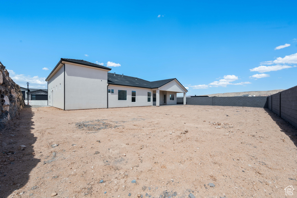 Back of property featuring a fenced backyard and stucco siding