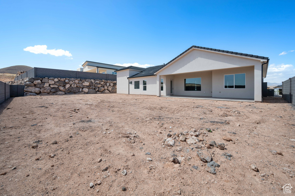 Back of property featuring a fenced backyard, stucco siding, and a patio