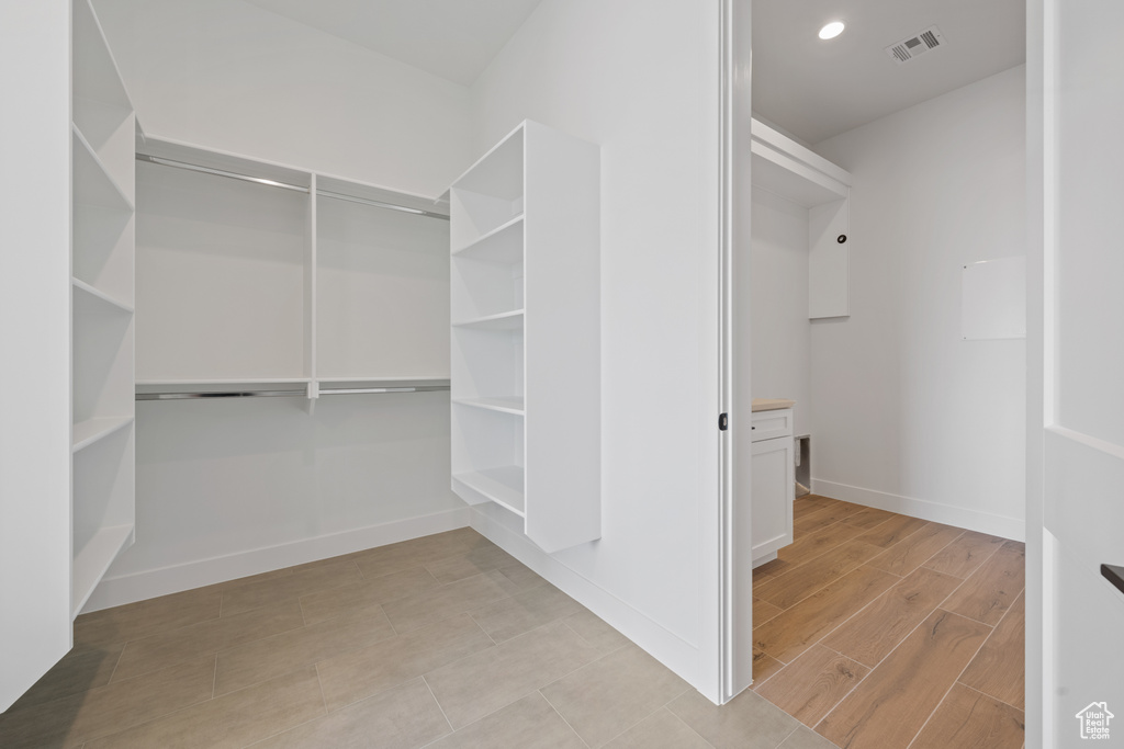 Walk in closet with light wood-type flooring