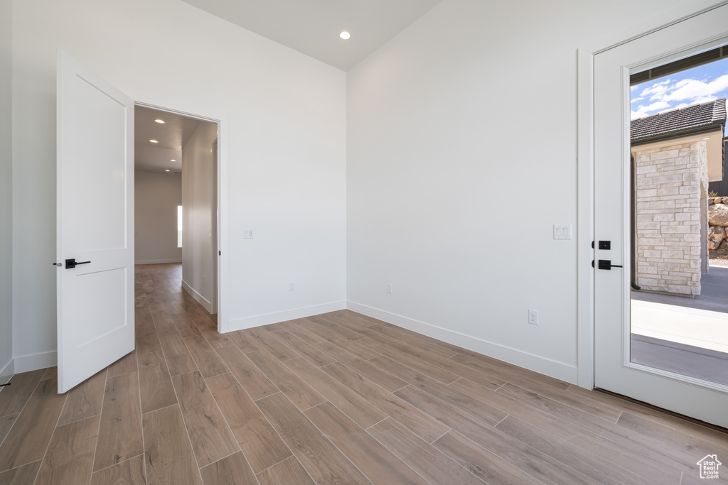 Unfurnished room featuring light wood-style floors, baseboards, and recessed lighting