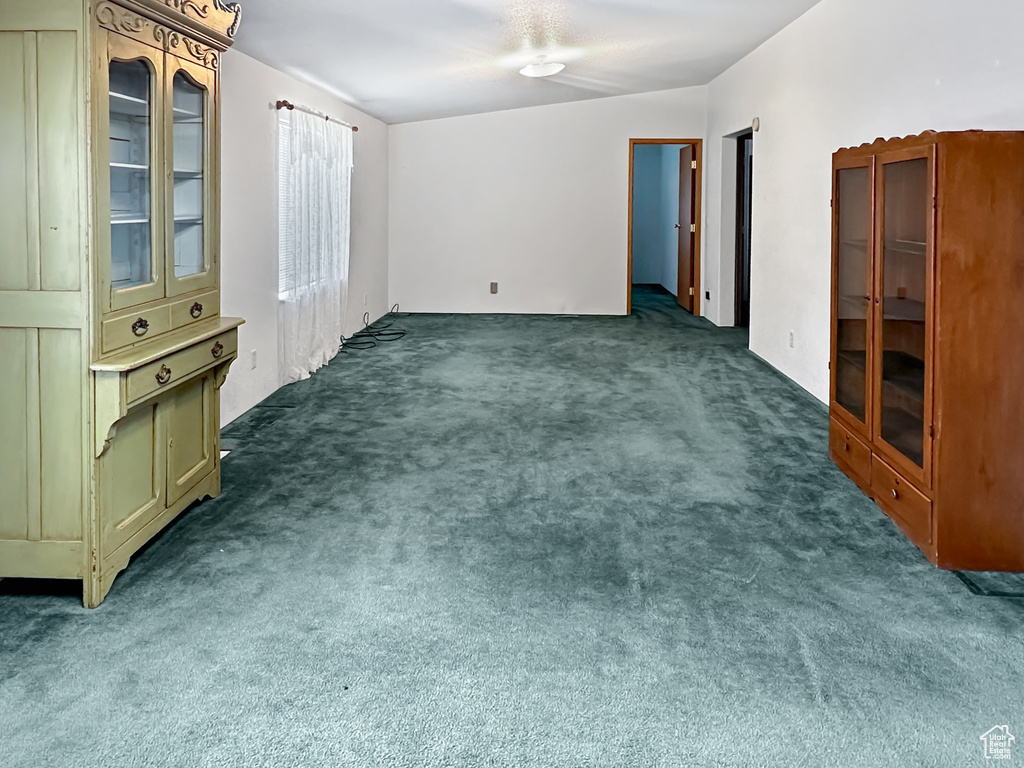 Unfurnished room featuring dark carpet