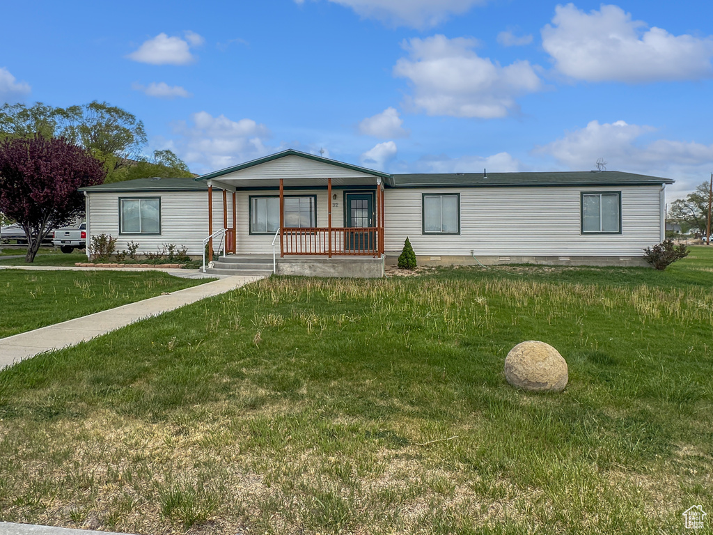 Manufactured / mobile home with covered porch and a front yard