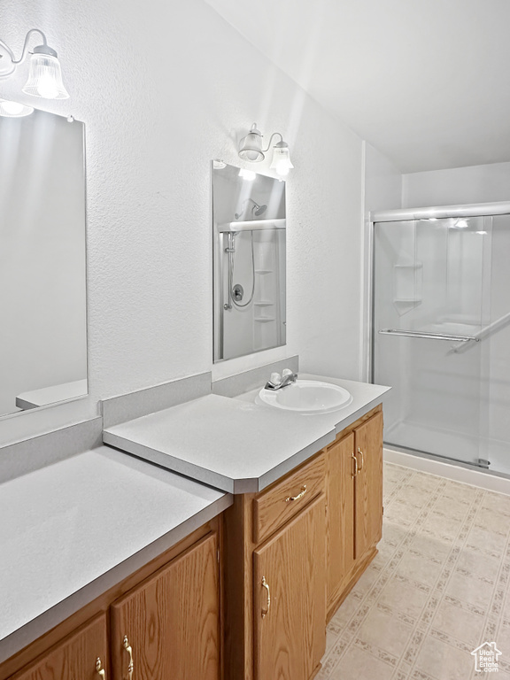 Full bath featuring a shower stall, tile patterned floors, and vanity