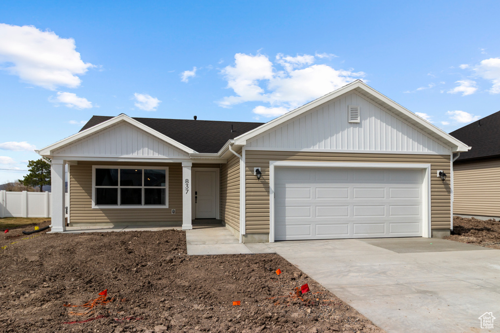 Ranch-style home with an attached garage, driveway, and fence