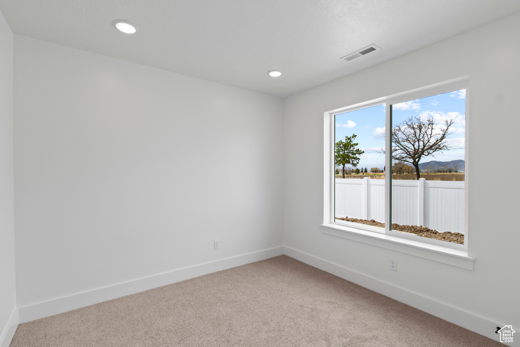 Spare room featuring carpet floors, baseboards, and recessed lighting