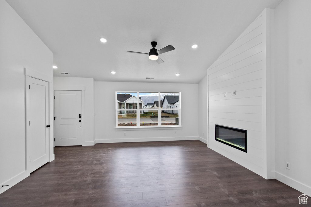 Unfurnished living room with a ceiling fan, a large fireplace, dark wood-type flooring, recessed lighting, and baseboards