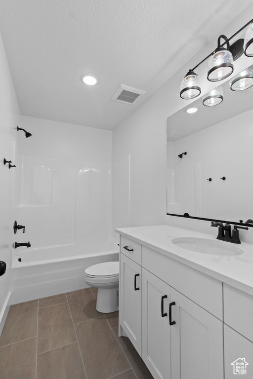 Full bathroom featuring toilet, shower / washtub combination, vanity, a textured ceiling, and tile patterned flooring