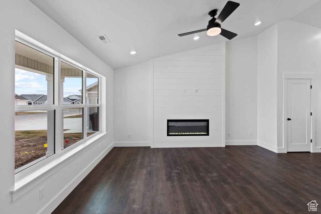 Unfurnished living room with lofted ceiling, wood finished floors, a fireplace, a ceiling fan, and baseboards