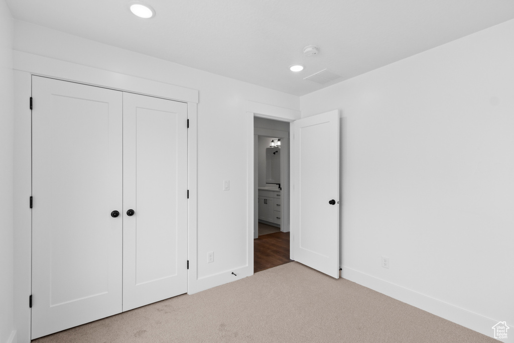 Unfurnished bedroom with carpet, baseboards, recessed lighting, and a closet