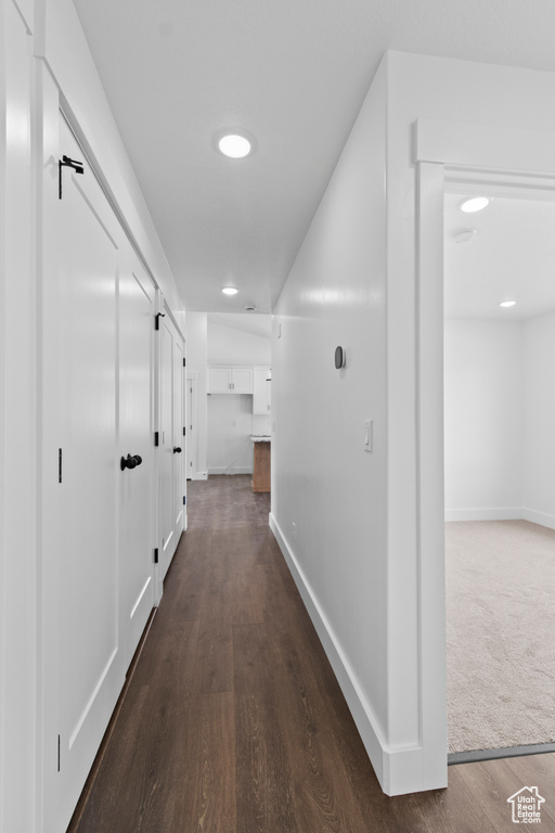 Hallway featuring dark wood-style floors and baseboards