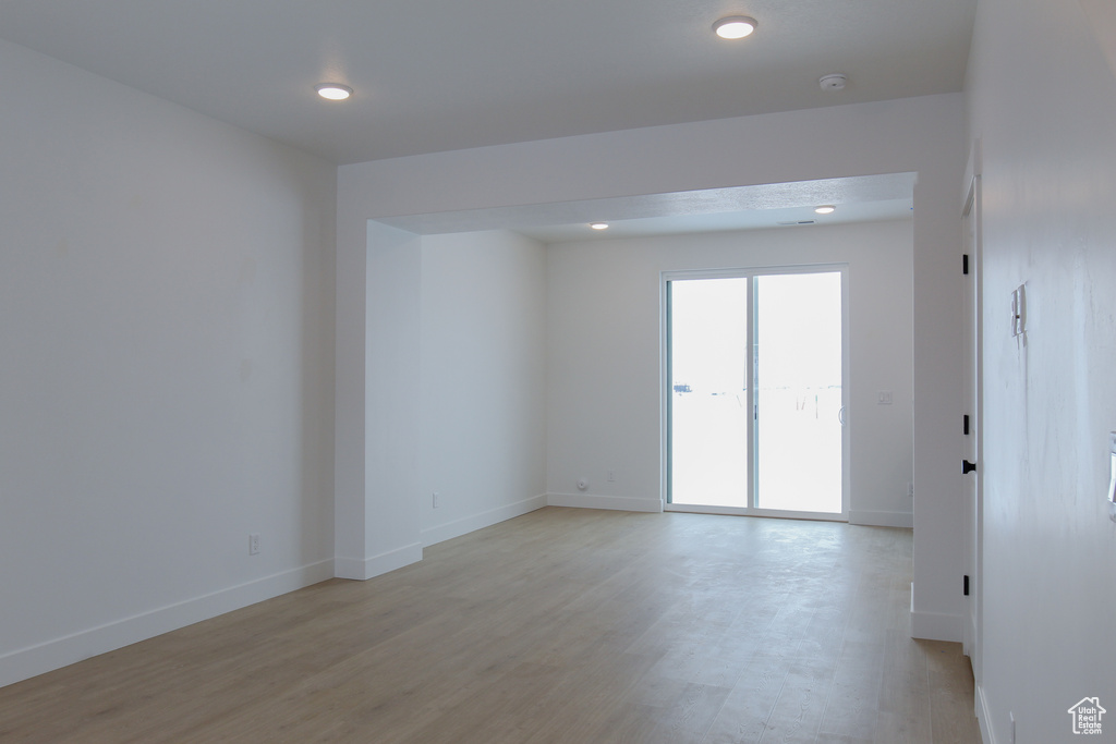 Unfurnished room with light wood finished floors, baseboards, a smoke detector, and recessed lighting