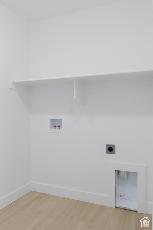 Washroom featuring light wood-style flooring, hookup for an electric dryer, washer hookup, and baseboards