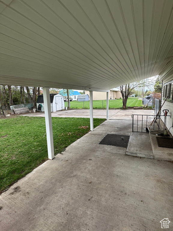 View of patio / terrace featuring a storage shed and an outbuilding