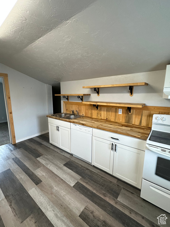 Kitchen featuring white appliances, a sink, butcher block countertops, open shelves, and white cabinets